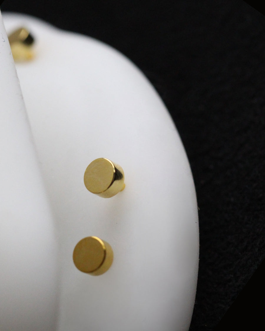 Close-up of a white object with gold studs on a black background