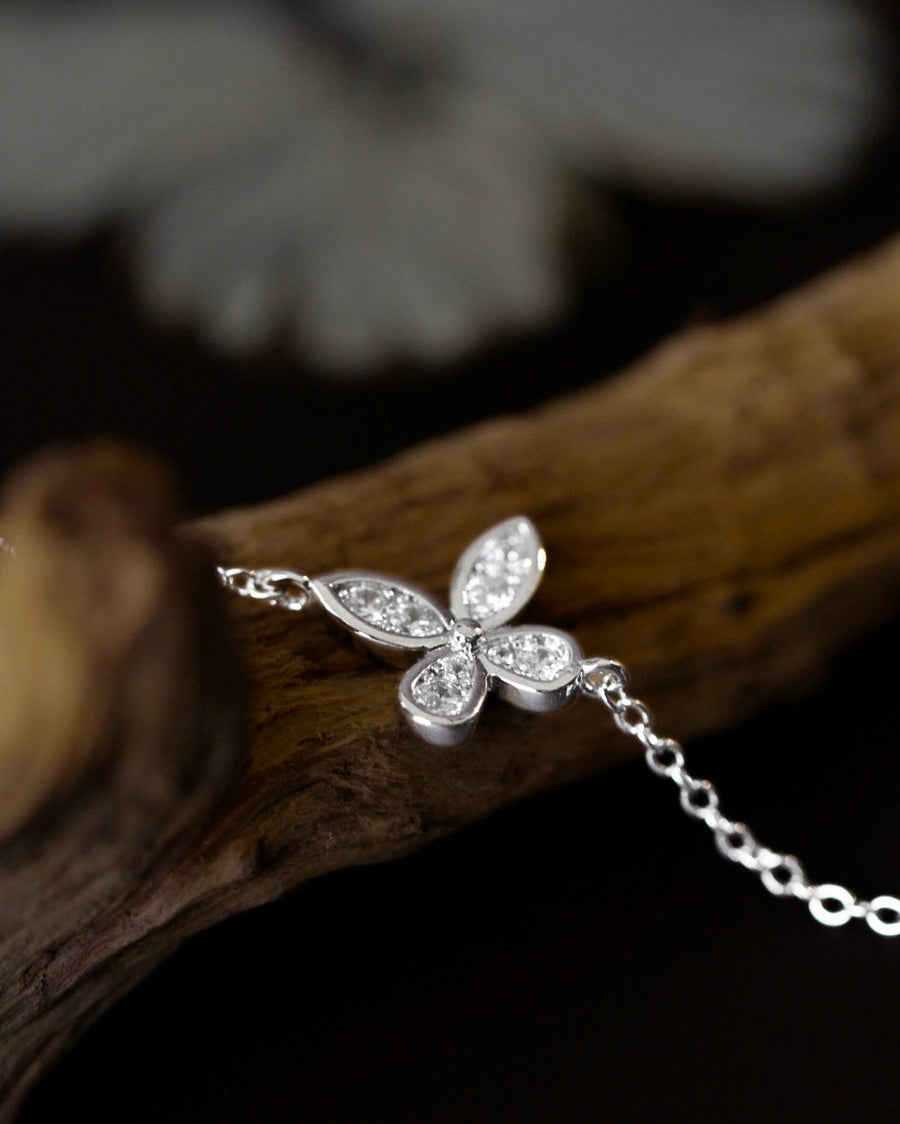 Close up  of Silver butterfly bracelet on a wooden surface with a blurred background