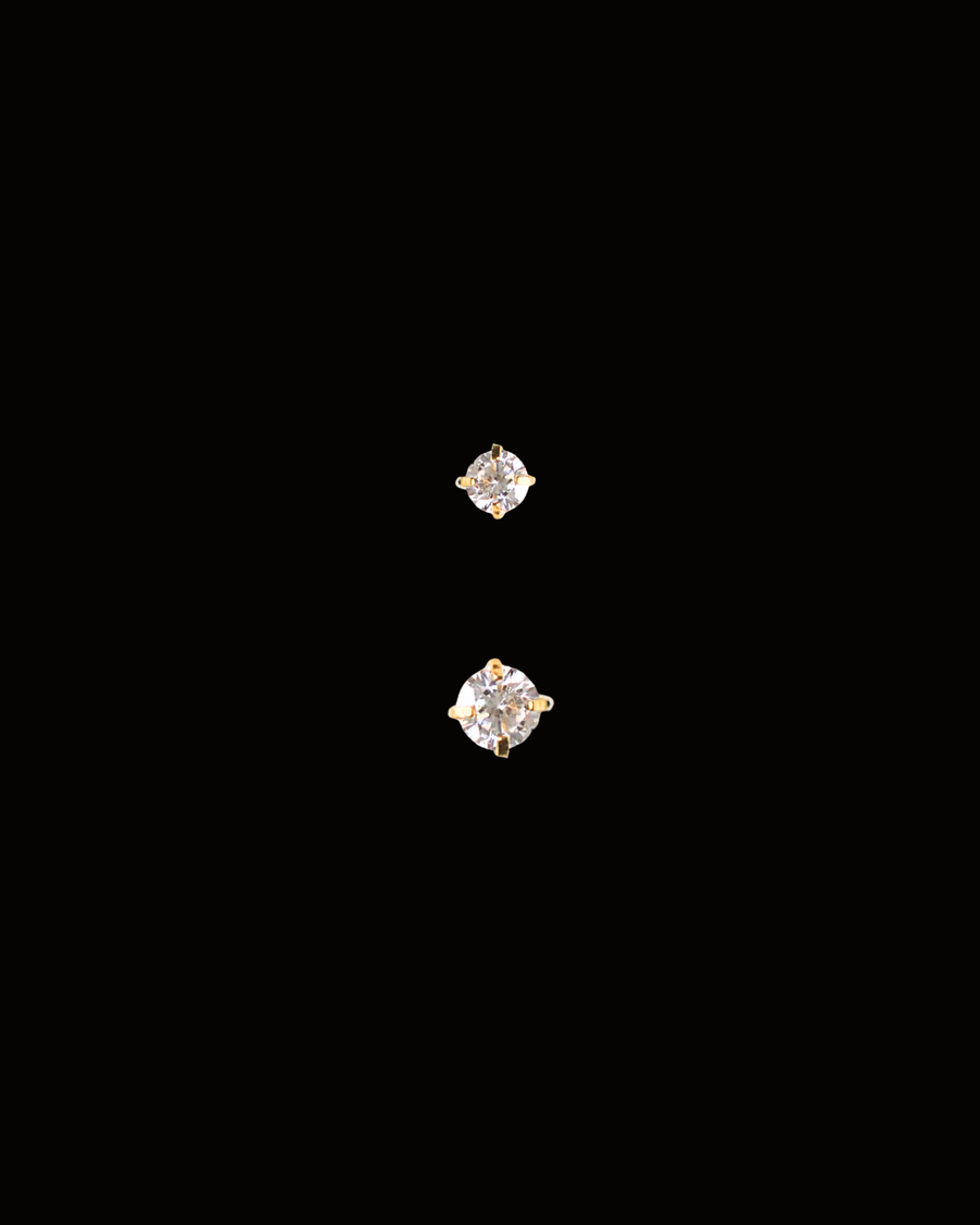 Two diamond stud earrings on a black background
